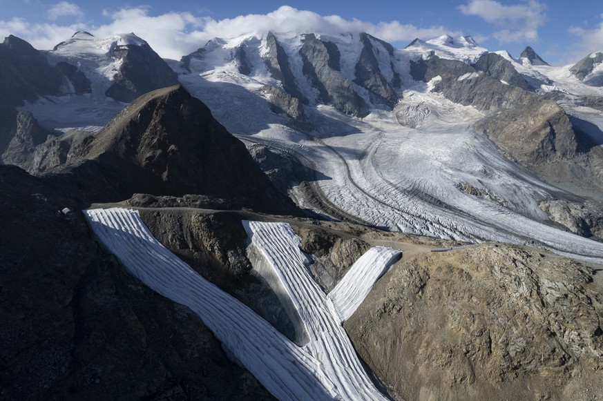 ARCHIV - 10.08.2022, Schweiz, Pontresina: Skipisten auf der Diavolezza vor der Berninagruppe mit Pers- und Morteratschgletscher sind mit Vlies bedeckt. Die Gletscher in den Schweizer Alpen sind dieses ...