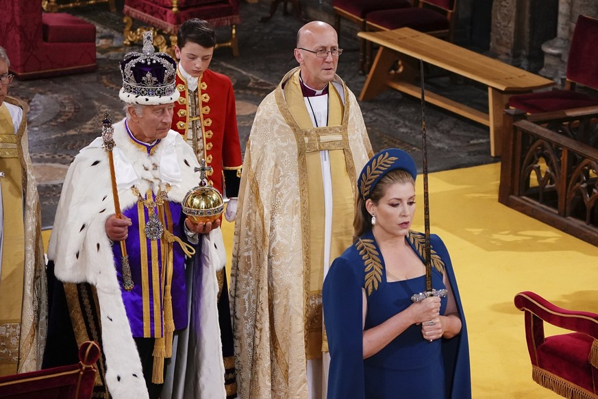 ARCHIV - 06.05.2023, Großbritannien, London: Penny Mordaunt (r), britische Abgeordnete, geht als Schwertträgerin vor König Charles III. während seiner Krönungszeremonie in der Westminster Abbey. (zu d ...