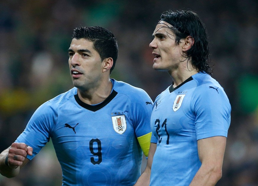 Edinson Cavani (right) and Luis Suarez of Uruguay argue with assistant referee Ian Hussin Brazil v Uruguay,