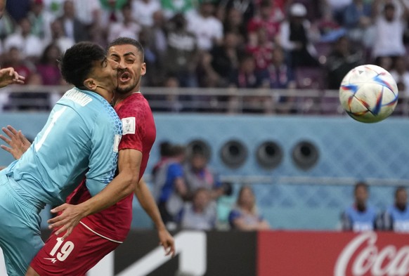 Iran's goalkeeper Alireza Beiranvand collides with Iran's Majid Hosseini, right, during the World Cup group B soccer match between England and Iran at the Khalifa International Stadium in Do ...