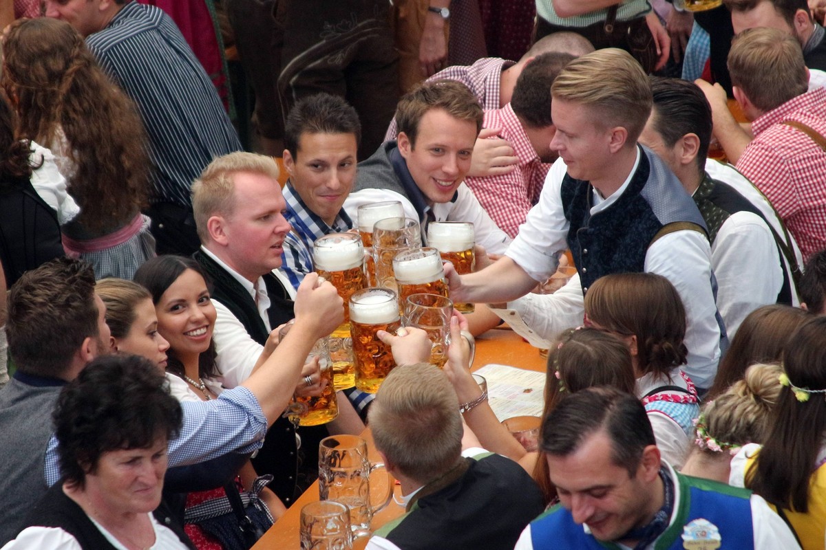 Oktoberfest M�nchen: Ausgelassen feiernde junge Leute sto�en gemeinsam mit einer Ma� Bier an, Bayern, Deutschland *** Oktoberfest Munich omitted Feiernde Boy People encounter together with a Mass Beer ...