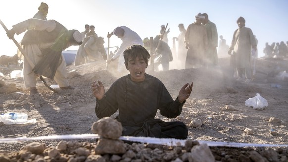 An Afghan boy mourns next to the grave of his little brother who died due to an earthquake, in Zenda Jan district in Herat province, western of Afghanistan, Monday, Oct. 9, 2023. Saturday&#039;s deadl ...