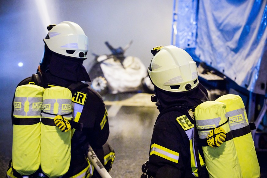 Feuerwehrleute mit schwerem Atemschutz und Strahlrohren bekaempfen einen Autobrand nach Unfall in einem verrauchten Strassentunnel, Brandschutzuebung, B 14 Tunnel Leutenbach,18.11.2017. | Verwendung w ...