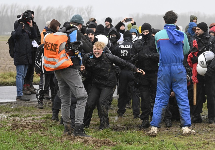 12.01.2023, Nordrhein-Westfalen, Keyenberg: Rangelei zwischen Demonstranten und Polizisten. Der Energiekonzern RWE will die unter Lützerath liegende Kohle abbaggern - dafür soll der Weiler auf dem Geb ...