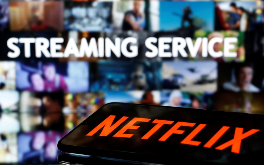 FILE PHOTO: A smartphone with the Netflix logo lies in front of displayed &quot;Streaming service&quot; words in this illustration taken March 24, 2020. REUTERS/Dado Ruvic/File Photo