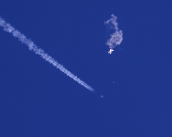 dpatopbilder - 04.02.2023, USA, -: Auf diesem von Chad Fish zur Verfügung gestellten Bild schweben die Überreste eines großen Ballons über dem Atlantischen Ozean vor der Küste South Carolinas. Darunte ...