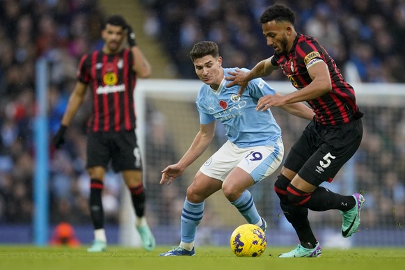 Manchester City&#039;s Julian Alvarez, center, duels for the ball with Bournemouth&#039;s Lloyd Kelly during the English Premier League soccer match between Manchester City and Bournemouth at the Etih ...