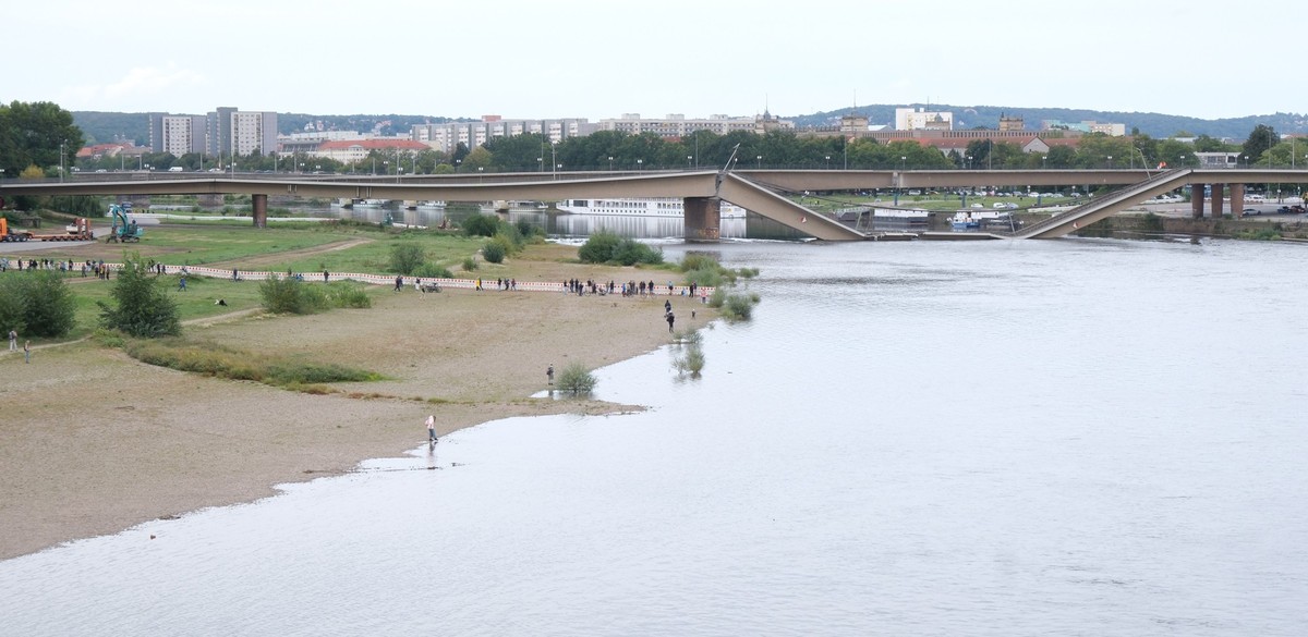 12.09.2024, Sachsen, Dresden: Schaulustige kommen an die teilweise eingestürzte Carolabrücke an die Elbe. Am Tag zwei nach dem Einsturz des Bauwerkes werden Vorkehrungen auf ein eventuell auftretendes ...
