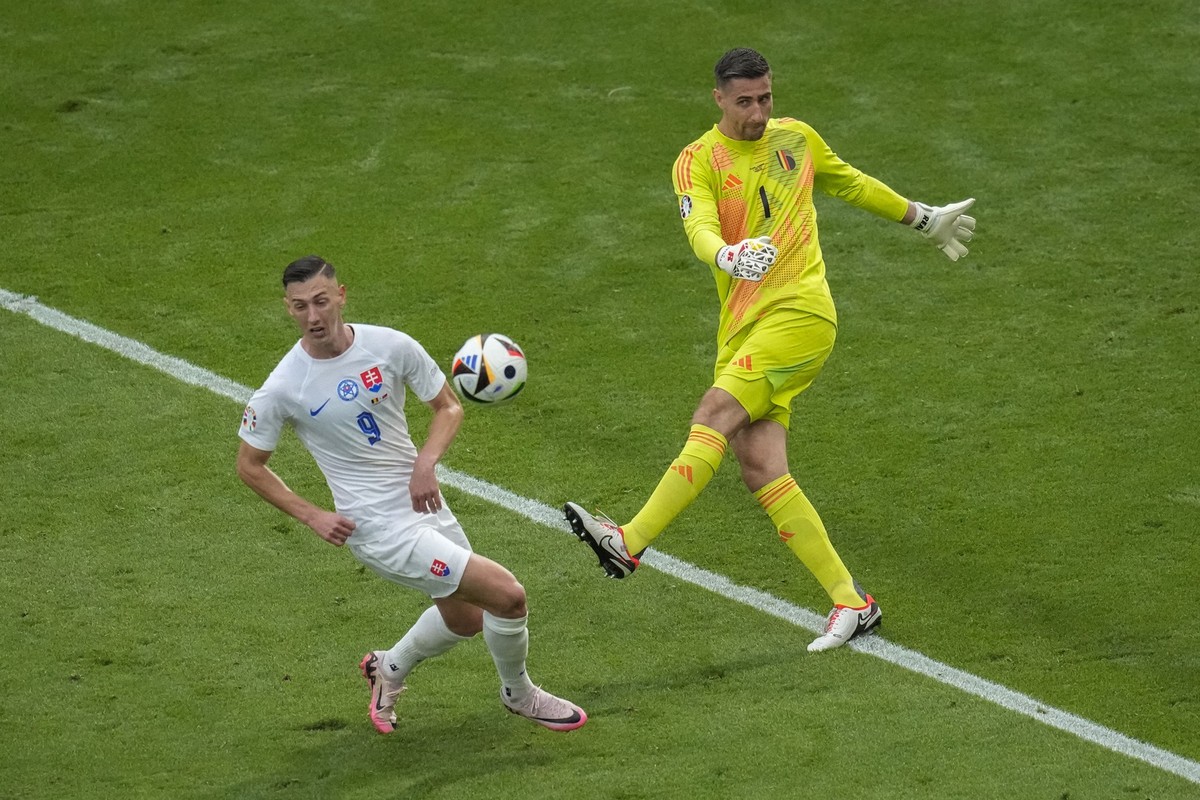 Belgium goalkeeper Koen Casteels, right, clears the ball next to Slovakia&#039;s Robert Bozenik during the Group E match between Belgium and Slovakia at the Euro 2024 soccer tournament in Frankfurt, G ...