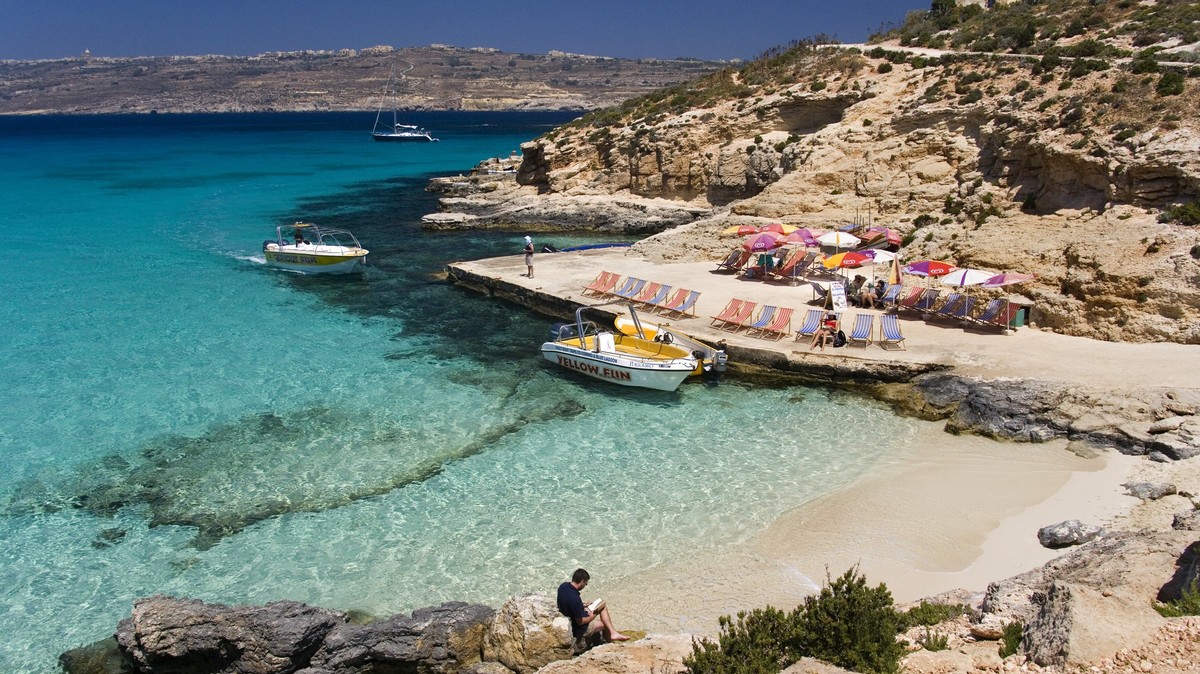 Malta - The Blue Lagoon on the tiny island of Comino with Gozo in the distance, The Blue Lagoon on the tiny island of Comino with Gozo in the distance. Malta, The Blue Lagoon on the tiny island of Com ...