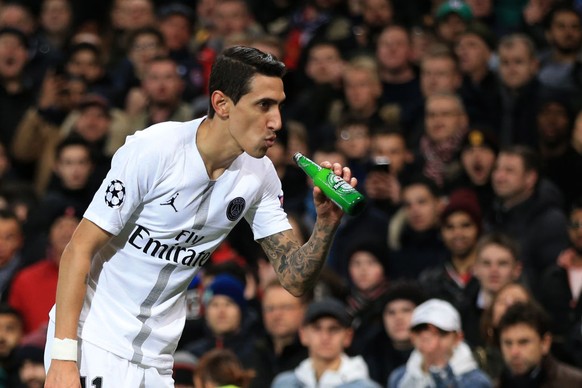 MANCHESTER, ENGLAND - FEBRUARY 12: Angel Di Maria of Paris Saint-Germain makes to drink from a bottle of beer thrown onto the pitch during the UEFA Champions League Round of 16 First Leg match between ...