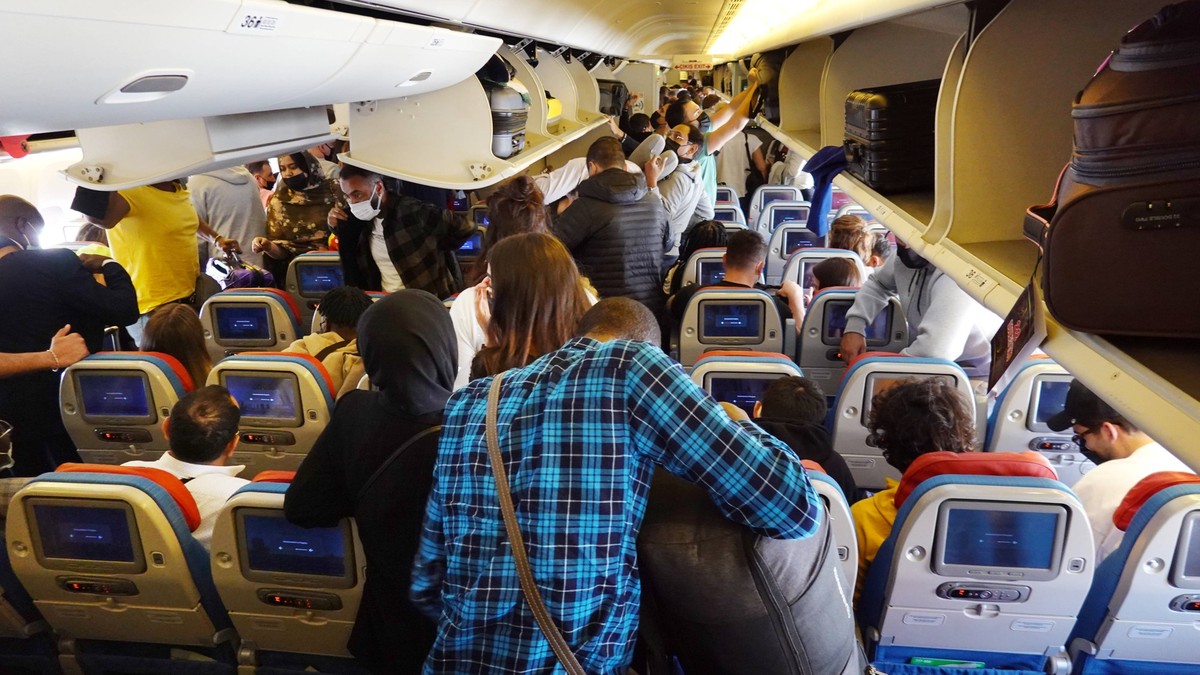 27.03.2022, Istanbul, TUR - Menschen holen in einer Flugzeugkabine der Turkish Airlines nach der Landung das Handgepaeck aus den Gepaeckfaechern. Airline, Alltag, asiatisch, Asien, Ausstieg, Bildschir ...
