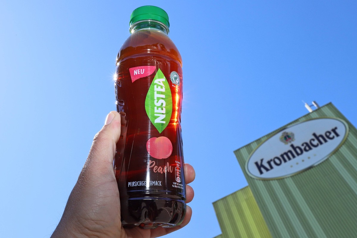 Eine Flasche Nestea in einer Hand vor der Krombacher Brauerei, die Krombacher Brauerei Bernhard Schadeberg GmbH & Co. KG steht seit Wochen in der Kritik, da sie mit der Firma Nestle (NestlÄ) zusam ...