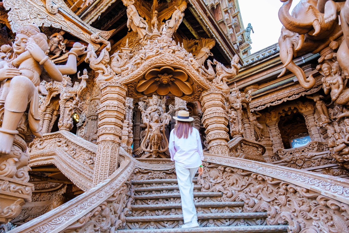 The Sanctuary of Truth wooden temple in Pattaya Thailand, sculpture of Sanctuary of Truth temple Asian women with hat visit The Sanctuary of Truth wooden temple in Pattaya Thailand, sculpture of Sanct ...