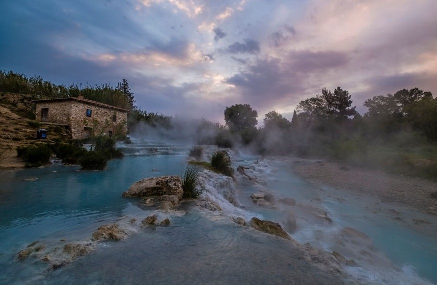 SATURNIA, TUSCANY, ITALY - 2019/04/29: Steam of the sulphurous water ascents over the white cascades of the thermal springs at sunrise. (Photo by Frank Bienewald/LightRocket via Getty Images)