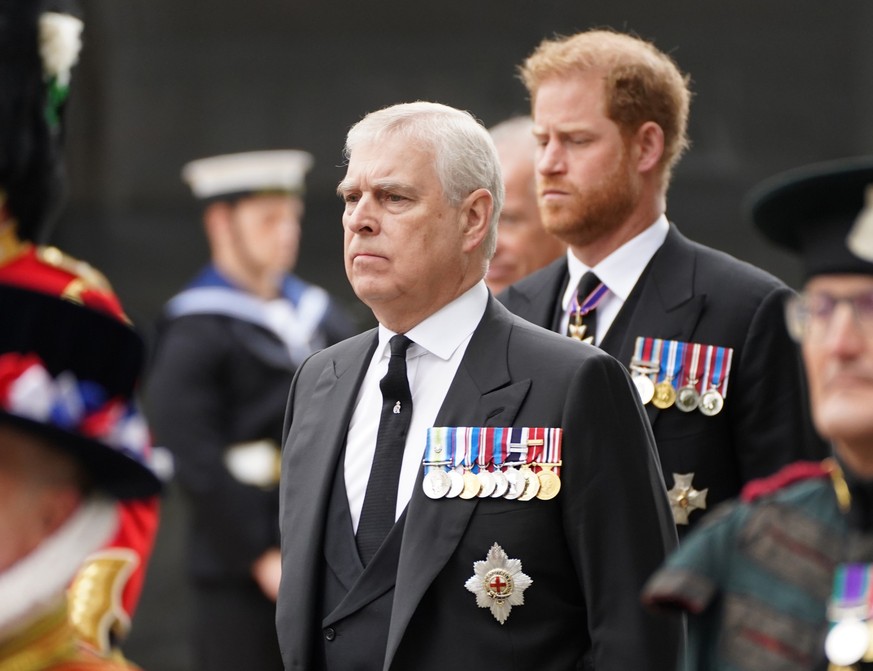 ARCHIV - 19.09.2022, Großbritannien, London: Prinz Andrew, Herzog von York (l), und der Herzog von Susssex, Prinz Harry (dahinter) kommen zum Staatsakt vor der Beisetzung von Königin Elizabeth II. in  ...