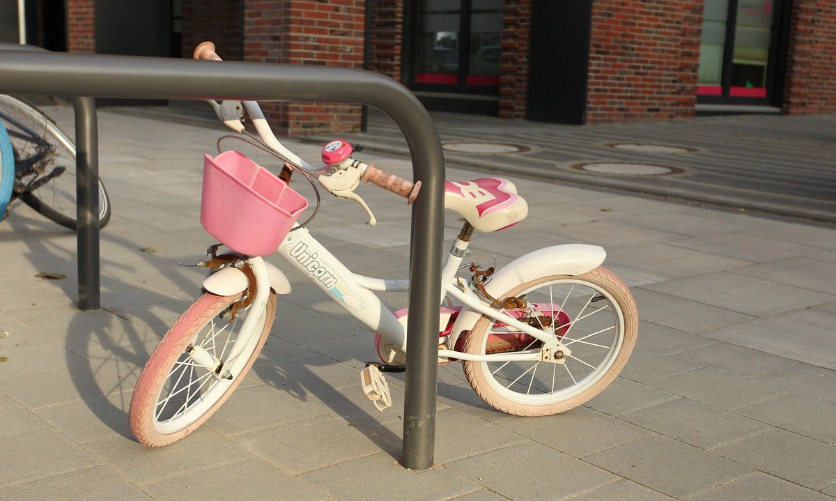 Ein Fahrrad der Marke Unicorn von einem kleinen Kind steht verlassen an einem Poller. Winterhude Hamburg *** A Unicorn bicycle belonging to a small child stands abandoned on a bollard in Winterhude Ha ...