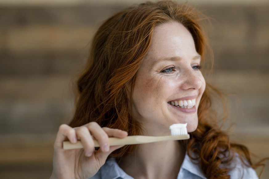 Portrait of laughing redheaded woman with toothbrush model released Symbolfoto property released PUBLICATIONxINxGERxSUIxAUTxHUNxONLY KNSF06519