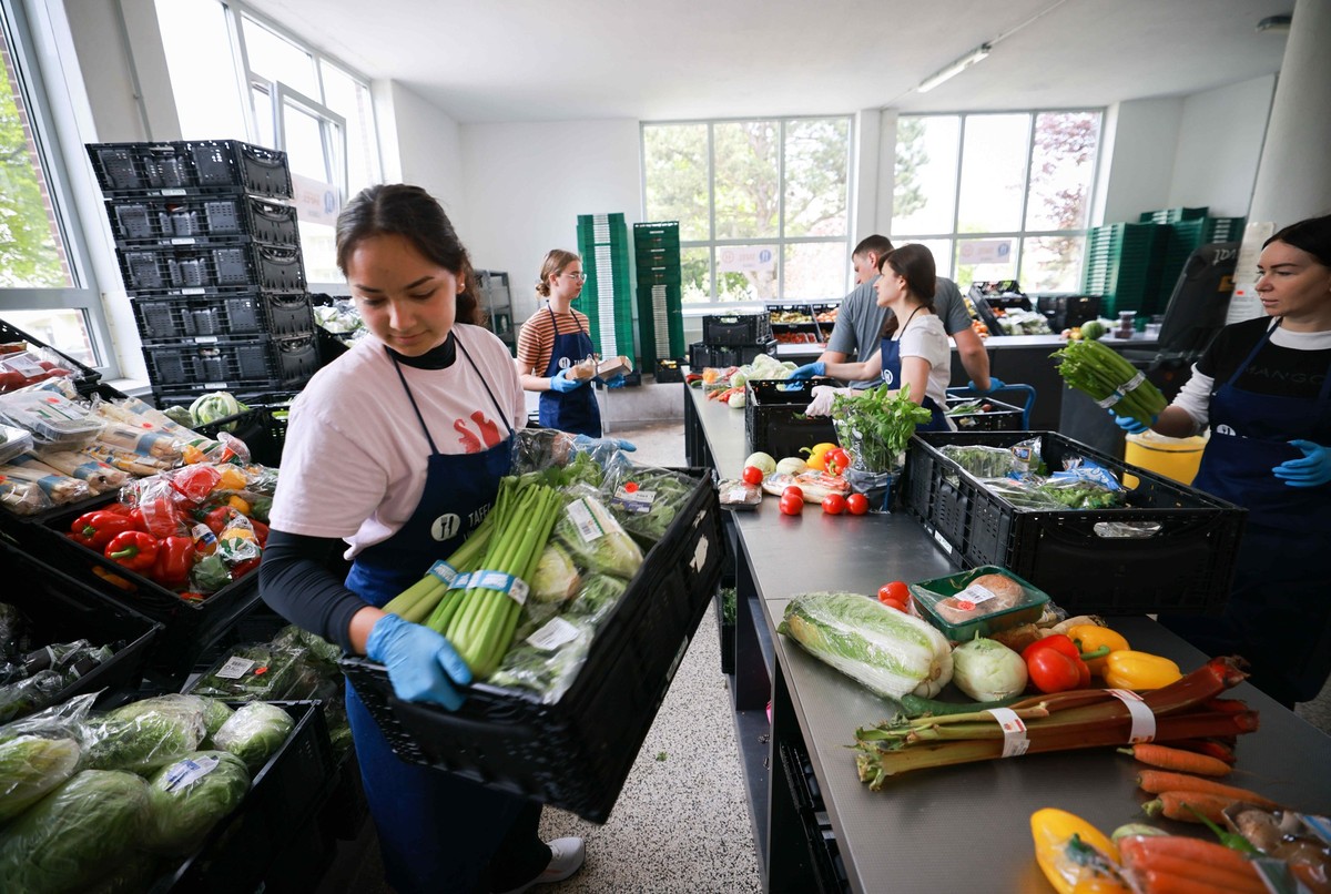 PRODUKTION - 15.05.2023, Schleswig-Holstein, Lübeck: Ehrenamtliche Helferinnen und Helfer entpacken und sortieren Lebensmittel in der Ausgabestelle der Jungen Tafel am Kolberger Platz. Bei der Jungen ...