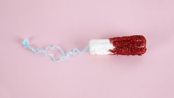 A hygienic tampon with red glitters instead of blood.&quot;nMinimal color still life and quirky photography