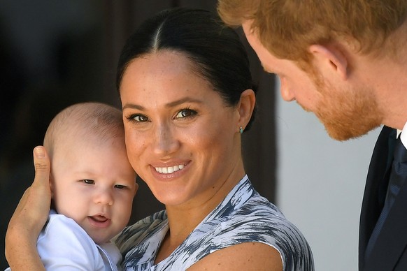 ARCHIV - 25.09.2019, S�dafrika, Kapstadt: Der britische Prinz Harry (r), Herzog von Sussex, und seine Frau Meghan (M), Herzogin von Sussex, kommen gemeinsam mit ihrem Sohn Archie (l) zu einem Besuch b ...