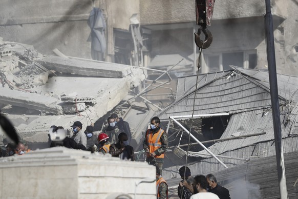 ARCHIV - 20.01.2024, Syrien, Damaskus: Rettungskräfte arbeiten an einem von einem Luftangriff getroffenen Gebäude in der syrischen Hauptstadt Damaskus. (zu dpa: «Aktivisten: Proiranische Kämpfer bei L ...
