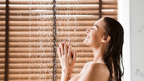 Woman Taking Shower Enjoying Water Splashing On Her, Side View